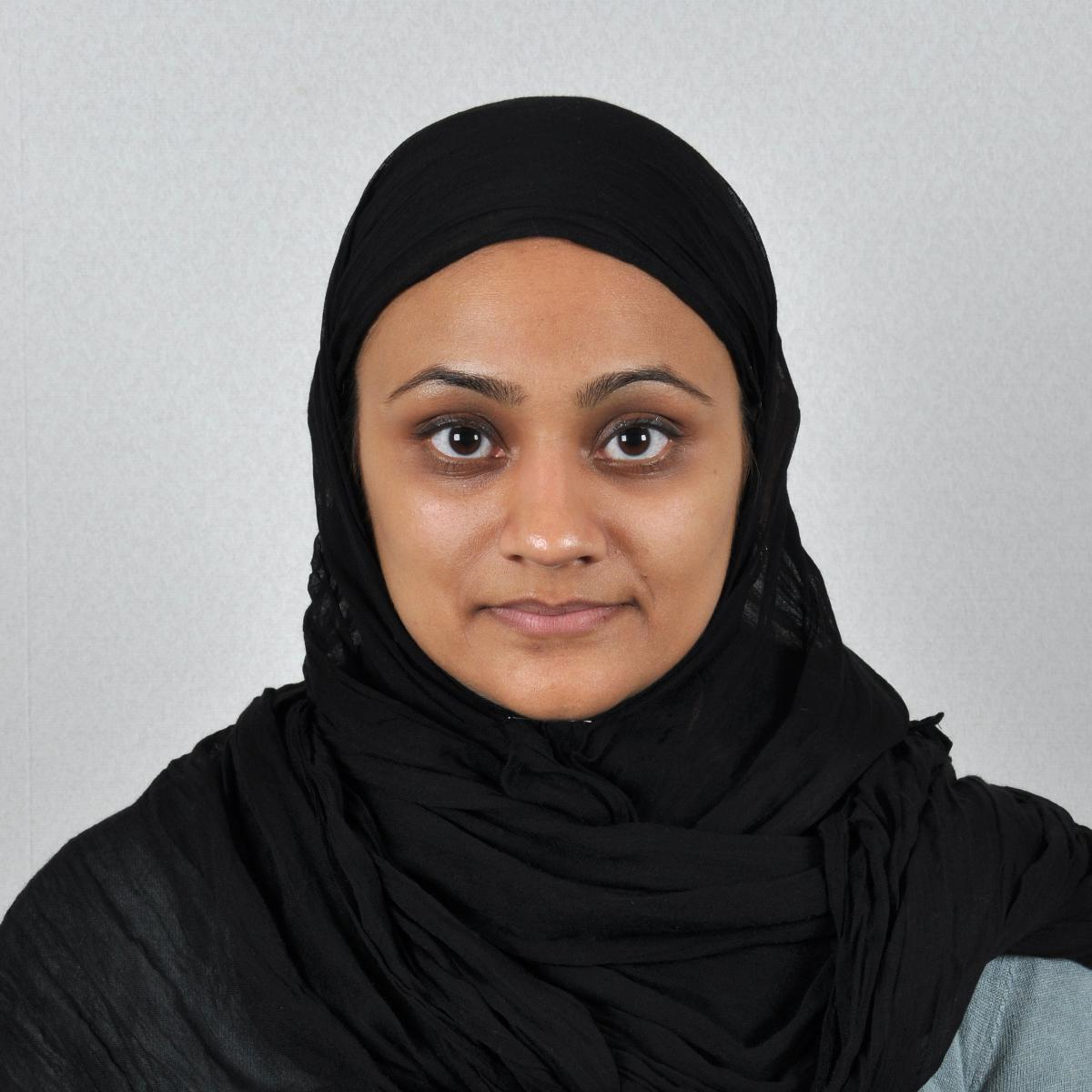 Photo of a woman wearing a head covering with her face fully visible and no shadows.