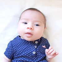 Photo of a baby facing forward with its eyes open.
