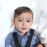 Photo of a boy by himself facing forward with his eyes open.