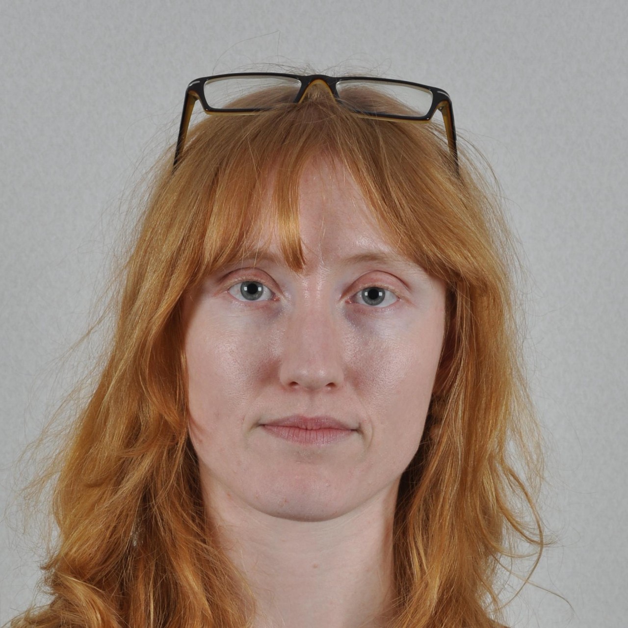 Foto de una mujer con las gafas apoyadas sobre la cabeza. 